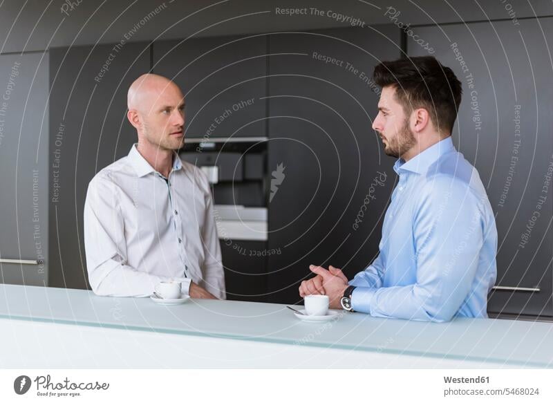 Two businessmen having a discussion in break room Businessman Business man Businessmen Business men business people businesspeople business world business life