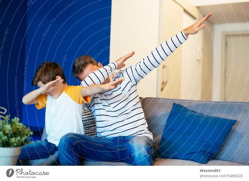 Father and son making a dab on couch at home settee sofa sofas couches settees dabbing father pa fathers daddy dads papa sons manchild manchildren parents