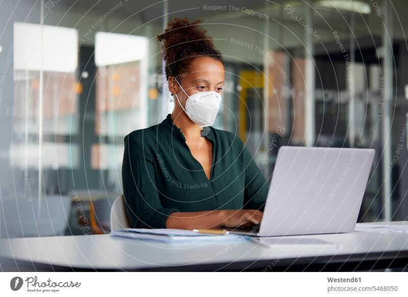 Portrait of businesswoman wearing protective mask working on laptop at counter Occupation Work job jobs profession professional occupation business life