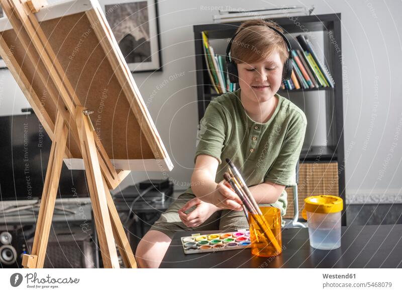 Boy painting at easel and listening to music human human being human beings humans person persons caucasian appearance caucasian ethnicity european 1