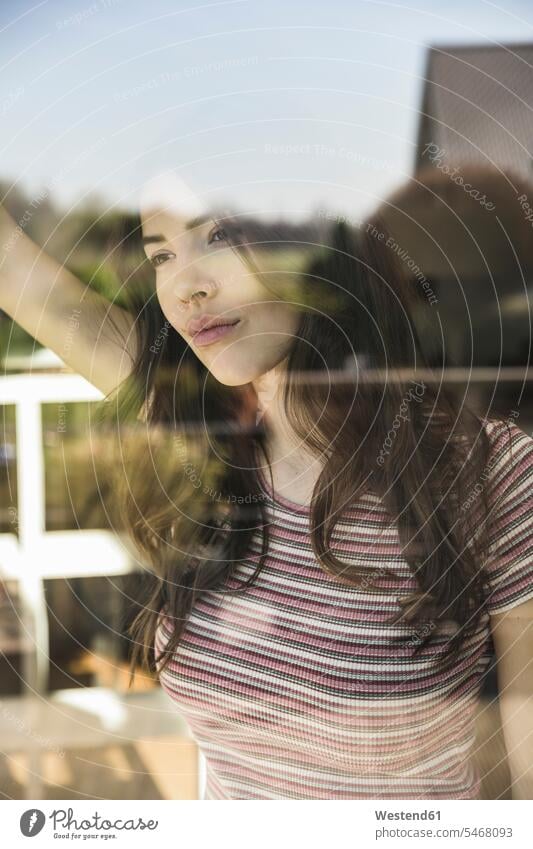 Portrait of pensive young woman behind windowpane window glass window glasses windowpanes Window Pane portrait portraits females women thoughtful Reflective