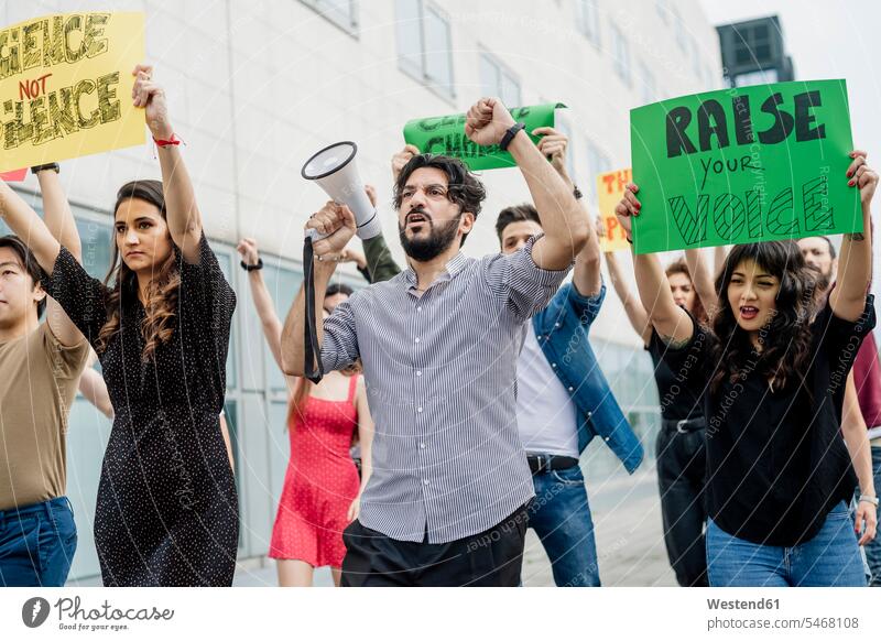 Multi ethnic activists protesting in city color image colour image casual clothing casual wear leisure wear casual clothes Casual Attire outdoors location shots