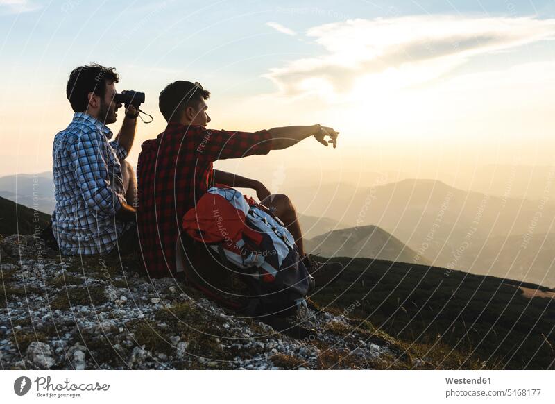 Italy, Monte Nerone, two hikers on top of a mountain enjoying the view at sunset View Vista Look-Out outlook mountains mountain range mountain ranges sunsets