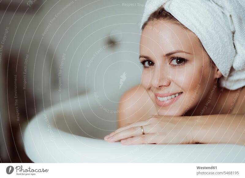 Portrait of smiling woman with towel around her head taking a bath at home Bath females women smile bathing bathe Taking A Bath towels portrait portraits heads