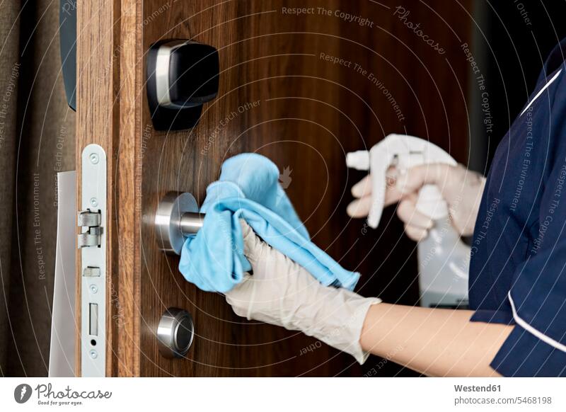 Close-up of chambermaid wiping doorknob in hotel color image colour image indoors indoor shot indoor shots interior interior view Interiors Millennials