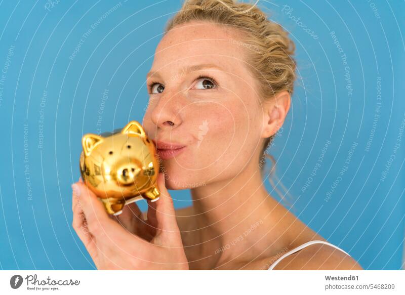 Portrait of blond woman kissing golden piggy bank human human being human beings humans person persons caucasian appearance caucasian ethnicity european 1