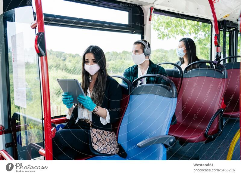 Passengers wearing protective masks in public bus, Spain transport motor vehicles road vehicle road vehicles buses busses headphone headset relax relaxing