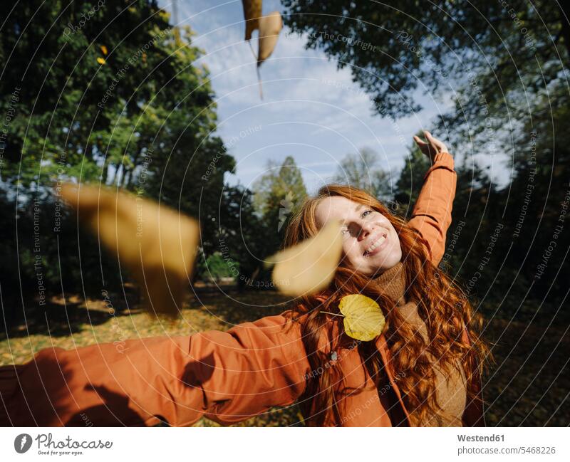 Happy redheaded woman enjoying autumn in a park human human being human beings humans person persons caucasian appearance caucasian ethnicity european 1
