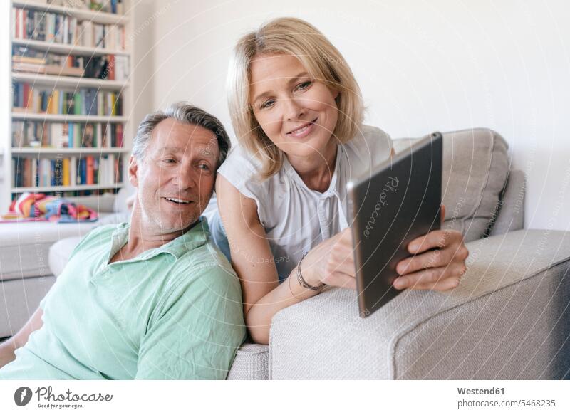 Smiling mature couple at home using tablet twosomes partnership couples smiling smile digitizer Tablet Computer Tablet PC Tablet Computers iPad Digital Tablet