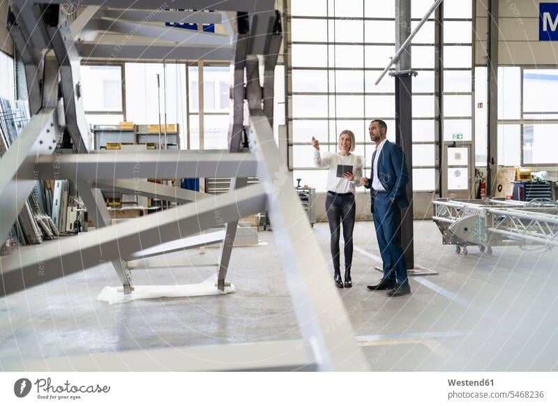 Businessman and young woman talking in a factory human human being human beings humans person persons Mixed Race mixed race ethnicity mixed-race Person