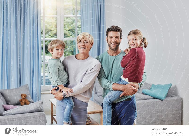 Portrait of happy family with two kids at home portrait portraits families happiness child children people persons human being humans human beings Lens Flare