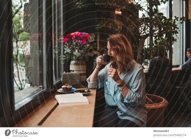 Young woman drinking from coffee cup in a cafe human human being human beings humans person persons caucasian appearance caucasian ethnicity european