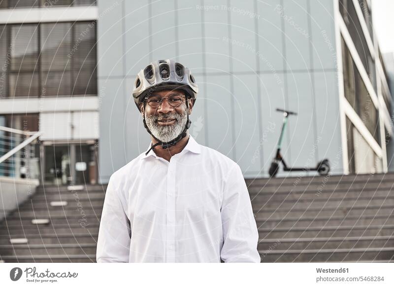 Portrait of smiling mature businessman with E-Scooter wearing cycling helmet business life business world business person businesspeople Business man