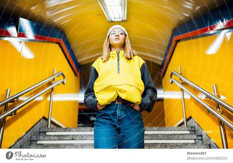 Young woman walking down stairs in underground station touristic tourists Eye Glasses Eyeglasses specs spectacles go going solitary colour colours stand