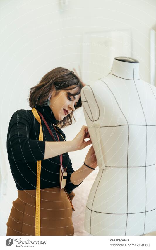 beautiful tailor women smiling when measure the mannequin chest