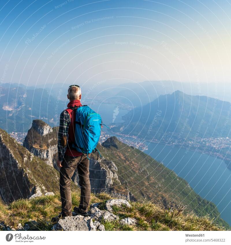 Rear view of hiker on mountaintop, Orobie Alps, Lecco, Italy human human being human beings humans person persons caucasian appearance caucasian ethnicity