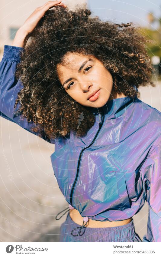 Portrait of stylish young woman wearing tracksuit outdoors human human being human beings humans person persons curl curled curls curly hair relax relaxing