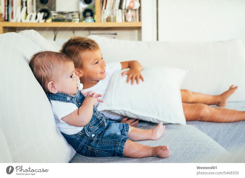 Two boys sitting on sofa and watching television at home human human being human beings humans person persons caucasian appearance caucasian ethnicity european