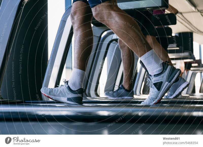 Legs of athletes running on treadmills in health club color image colour image indoors indoor shot indoor shots interior interior view Interiors gym gyms