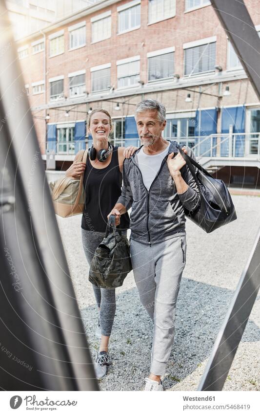Portrait of mature man and young woman with sports bag on the way tof gym gyms Health Club men males portrait portraits Gym Bag females women fitness Adults