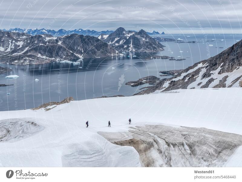 Greenland, Sermersooq, Kulusuk, Schweizerland Alps, three people walking in snow going group of people Group groups of people persons human being humans