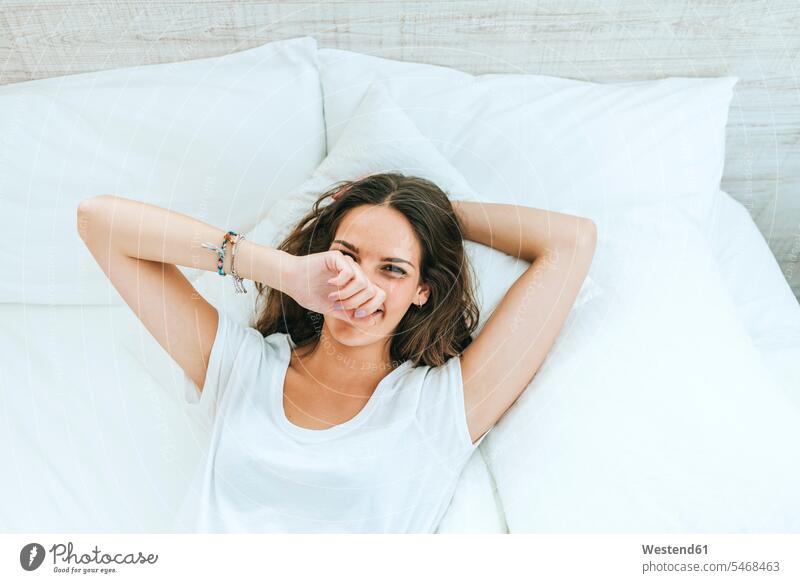 Portrait of happy young woman lying in bed at home human human being human beings humans person persons celibate celibates singles solitary people