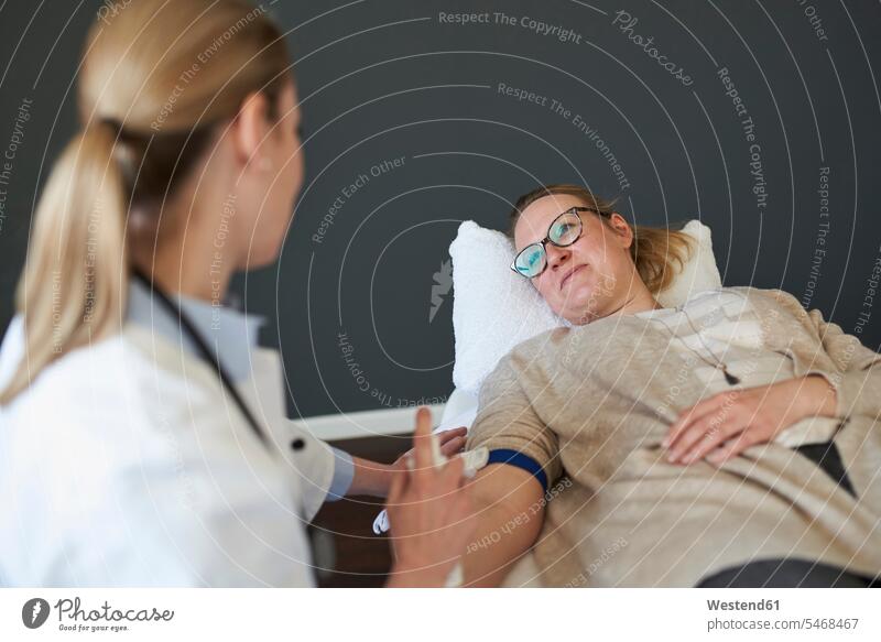 Female doctor preparing a blood sampling from patient in medical practice Preparation prepare surgeries surgery healthcare health-care patients Germany