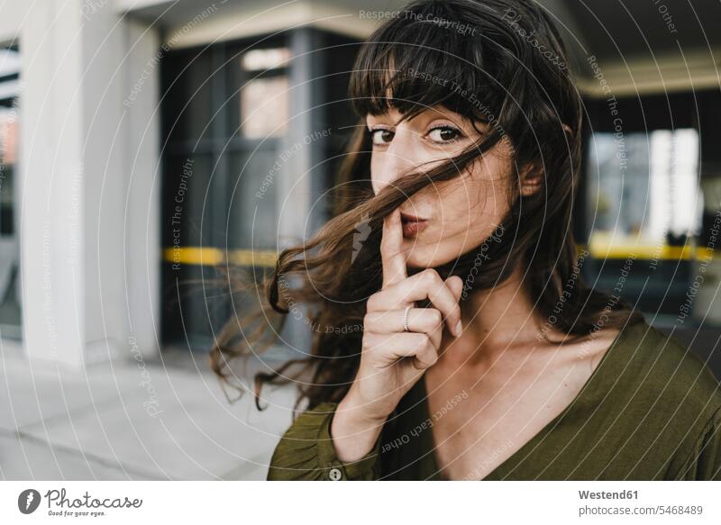 Portrait of smiling brunette woman, finger on mouth human human being human beings humans person persons caucasian appearance caucasian ethnicity european 1
