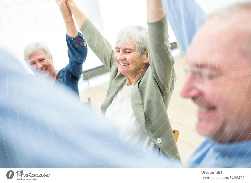 Group of seniors practicing chair gymnastics with instructor in retirement home human human being human beings humans person persons caucasian appearance