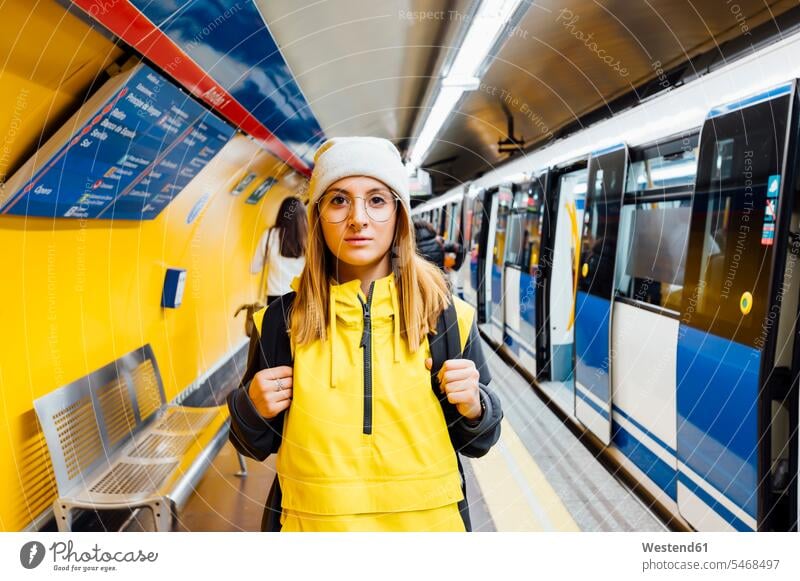Portrait of a young woman standing on underground station platform touristic tourists back-pack back-packs backpacks rucksack rucksacks transport railroad