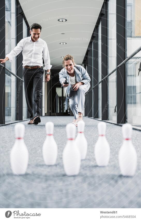 Happy businessman and businessman bowling in office passageway Office Offices businesswoman businesswomen business woman business women Businessman Business man