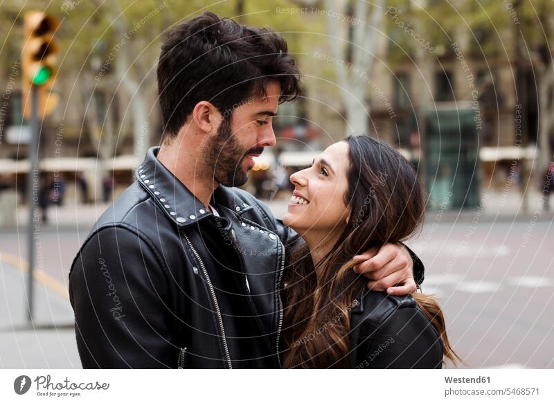 Spain, Barcelona, happy young couple hugging on the street happiness embracing embrace Embracement road streets roads twosomes partnership couples people