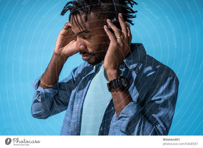 Portrait of stylish young man listening to music with headphones Disc Jockey disk jockey disk jockeys DJs watches wrist watches Wristwatch Wristwatches headset