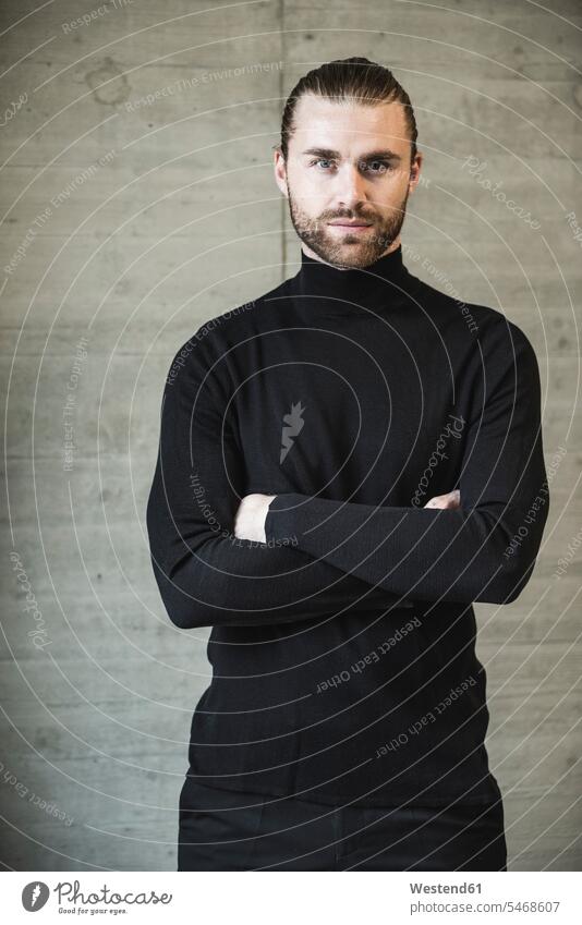 Portrait of confident young man wearing black turtleneck jumper portrait portraits pullover sweater Sweaters standing turtleneck pullover Self-confidence
