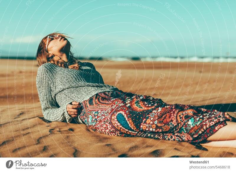 Young woman lying in desert landscape Deserts laying down lie lying down females women landscapes scenery terrain Adults grown-ups grownups adult people persons