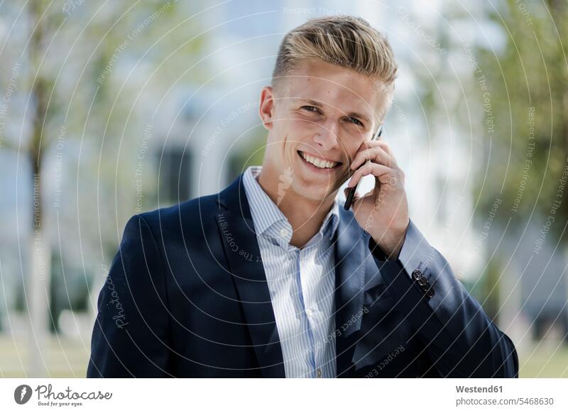 Portrait of smiling young businessman talking on cell phone Occupation Work job jobs profession professional occupation business life business world