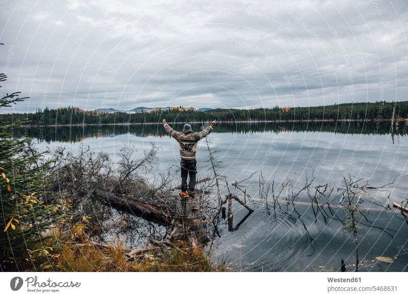 Canada, British Columbia, man standing at Blue Lake raising his arms lake lakes View Vista Look-Out outlook men males water waters body of water Adults