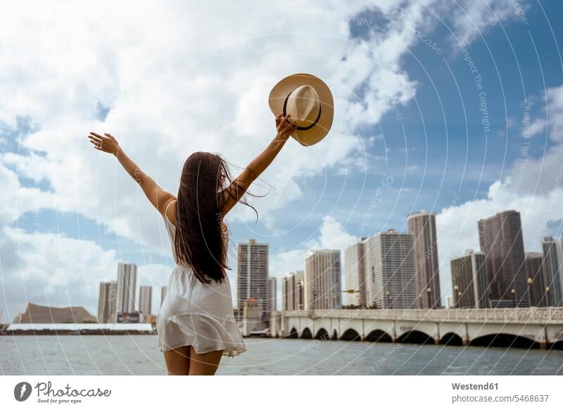 Young woman with arms outstretched standing in city color image colour image outdoors location shots outdoor shot outdoor shots day daylight shot daylight shots