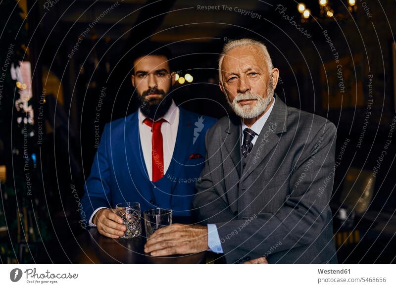 Portrait of two elegant men in a bar with tumblers Tumbler man males bars chic elegance stylishly classy portrait portraits Adults grown-ups grownups adult
