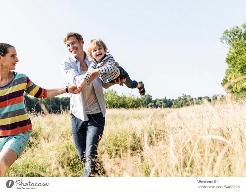 Happy family walking at the riverside on a beautiful summer day Meadow Meadows going summer time summery summertime happiness happy Plant Plants mid adult men
