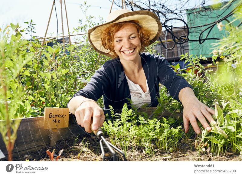 Happy young woman wearing straw hat urban gardening Urban Gardening Urban Farming Urban agriculture females women straw hats happiness happy Adults grown-ups