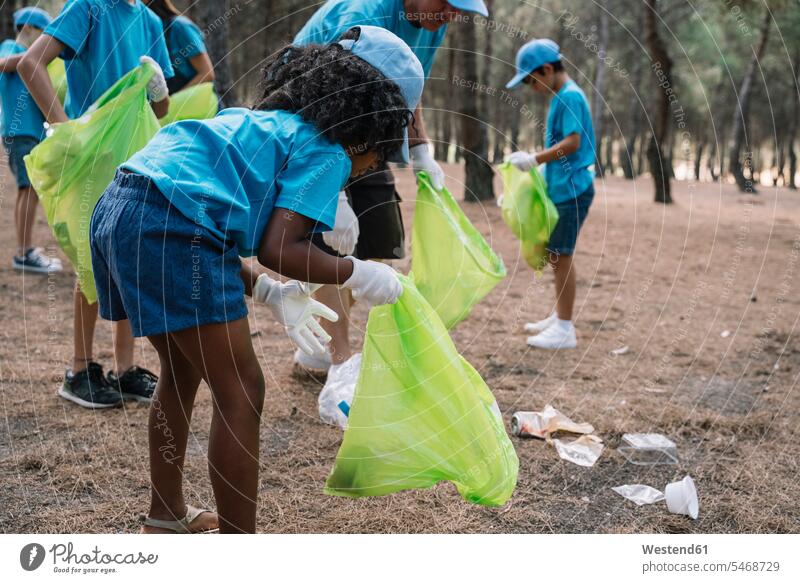 Group of volunteering children collecting garbage in a park human human being human beings humans person persons caucasian appearance caucasian ethnicity