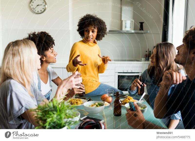 Friends sitting at table talking, eating and drinking beer Beer Beers Ale friends speaking Seated Table Tables Alcohol alcoholic beverage Alcoholic Drink
