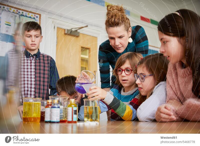 Children in a science lesson with a teacher pedagogues instructor teachers pupils schoolchild schoolchildren learn liquids sciences scientific natural sciences