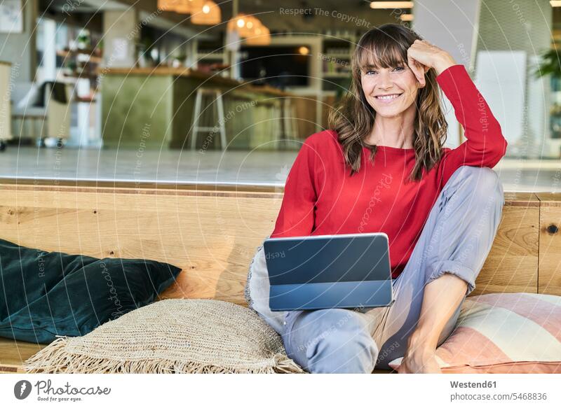 Woman using digital tablet while sitting at modern office color image colour image indoors indoor shot indoor shots interior interior view Interiors day