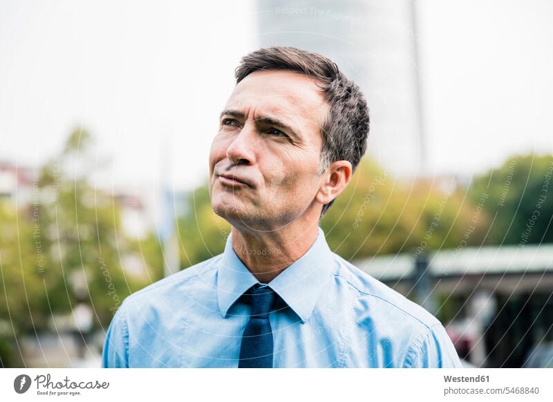 Portrait of businessman in city park thinking portrait portraits town cities towns parks Businessman Business man Businessmen Business men outdoors