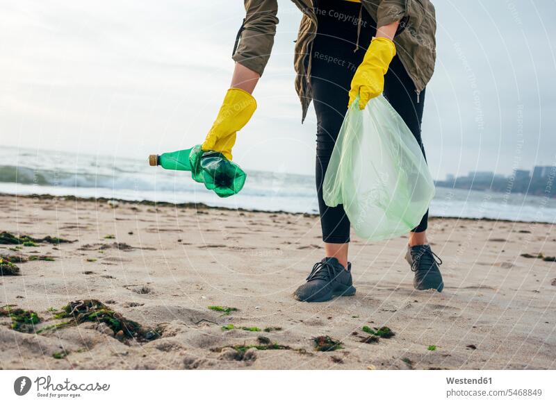 Environmentalist with garbage bag cleaning beach while standing against clear sky color image colour image outdoors location shots outdoor shot outdoor shots