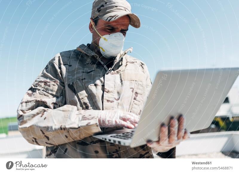 Soldier with face mask on emergency operation, using laptop Occupation Work job jobs profession professional occupation armed forces enlistee soldiers