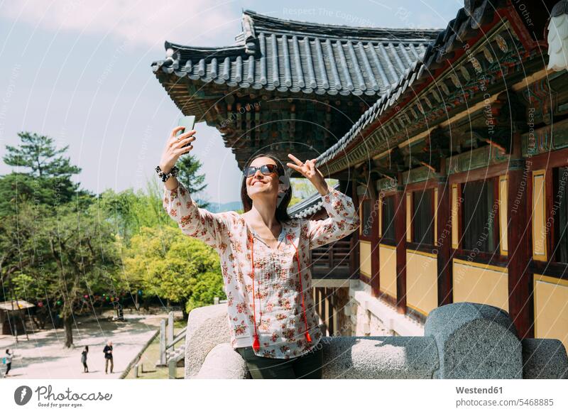 South Korea, Gyeongju, happy woman taking a selfie with cell phone in Bulguksa Temple happiness females women Selfie Selfies mobile phone mobiles mobile phones