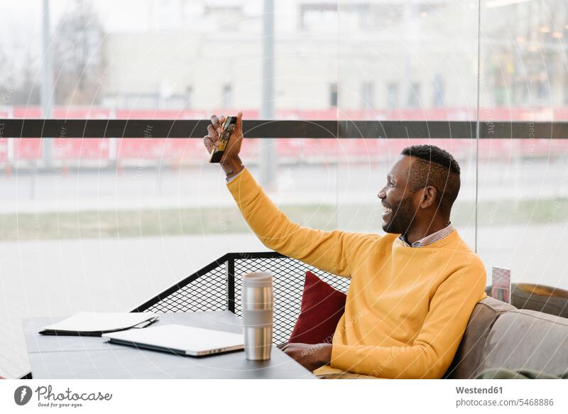 Happy man using smartphone in a cafe business life business world business person businesspeople Business man Business men Businessmen human human being